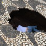 Mulher é “engolida” por cratera de 2 metros ao tentar atravessar rua; veja vídeo
